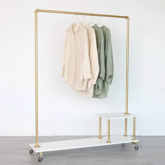 Gold clothing rack with white board in a room with framed pictures on the wall