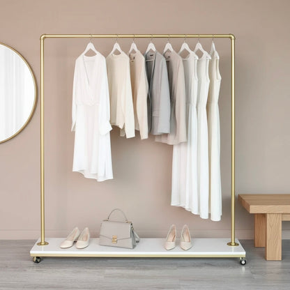 Gold clothing rack with white and gray garments, a handbag, and shoes on a neutral background.