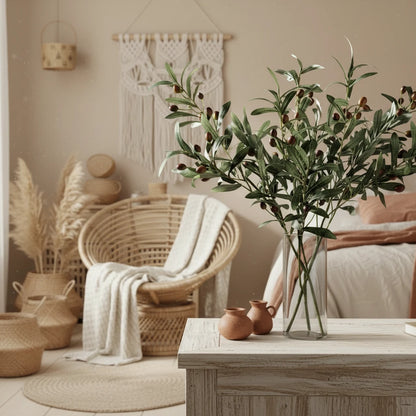 Artificial olive branch with green leaves and small brown fruits on a plain background